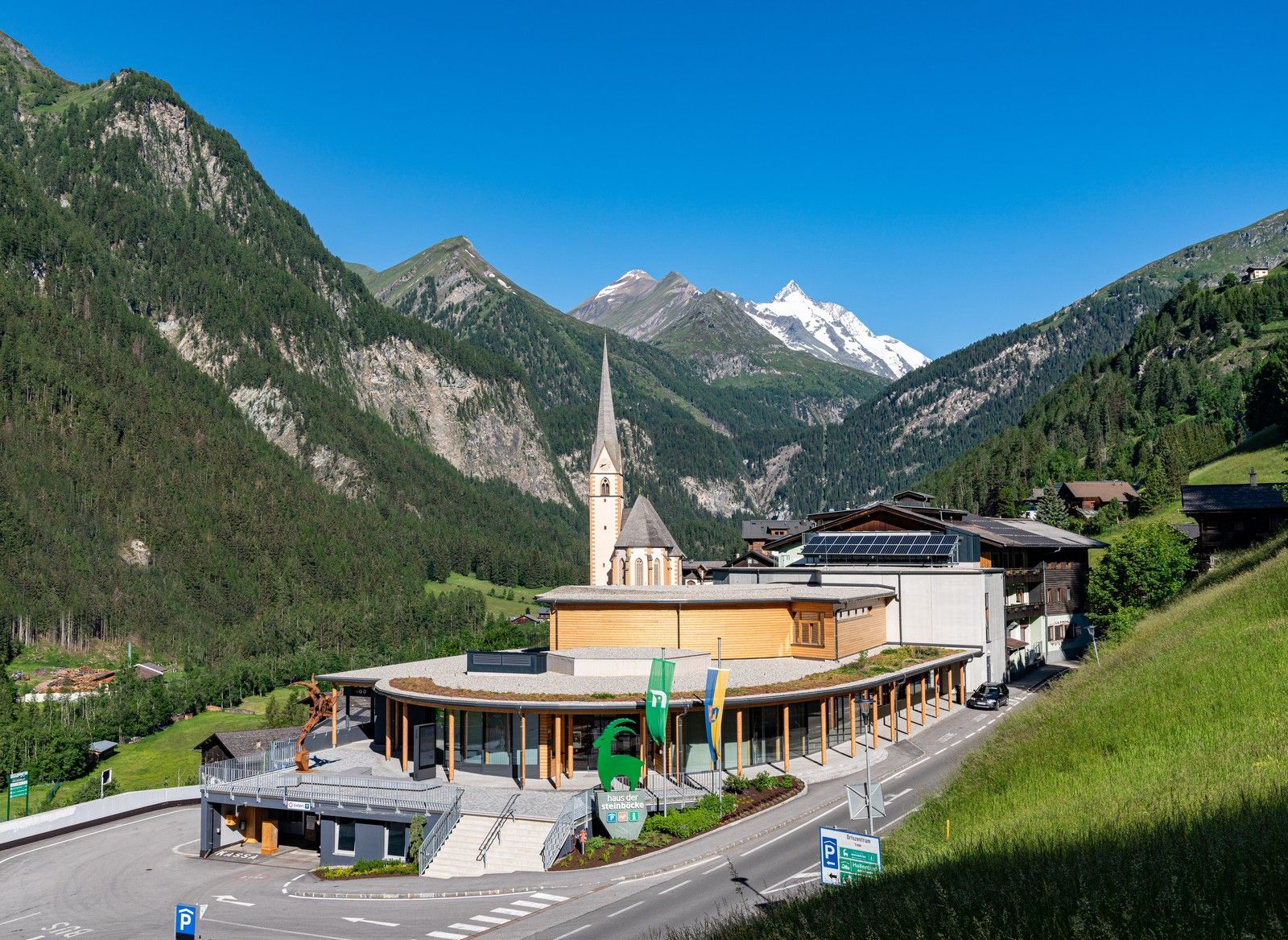 Haus der Steinböcke von oben mit Blick auf Kirche und schneebedeckte Berge