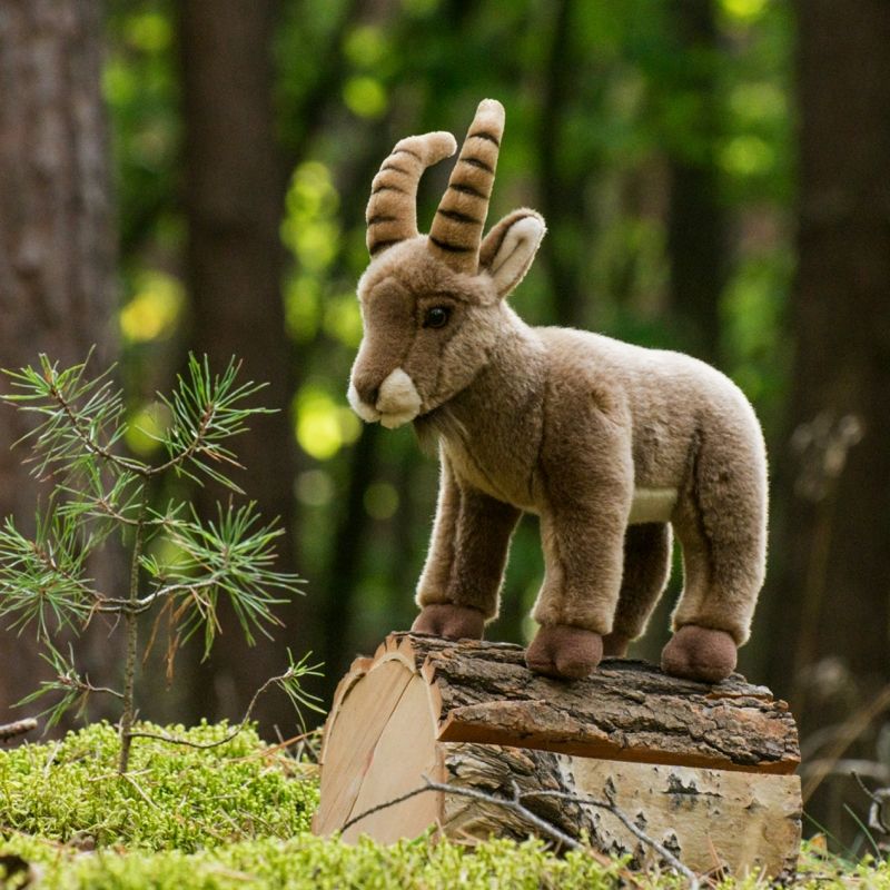 Steinbock als Plüschtier auf Holzklotz